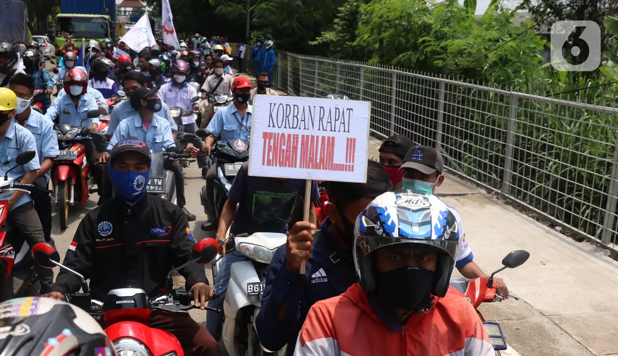 Buruh membawa spanduk saat konvoi di Kota Tangerang, Banten, Selasa (6/10/2020). Dalam aksi tersebut mereka menolak UU Omnibus Law Cipta Kerja yang sudah disahkan oleh DPR RI. (Liputan6.com/Angga Yuniar)