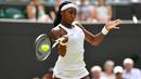 Petenis AS, Cori Gauff mengembalikan bola ke arah lawannya petenis Romania, Simona Halep pada babak keempat Wimbledon 2019 di All England Lawn Tennis Club, Senin (8/7/2019). Petenis berusia 15 tahun itu ditundukkan Halep, yang unggulan ke-7 turnamen, dengan skor 3-6, 3-6. (GLYN KIRK/AFP)