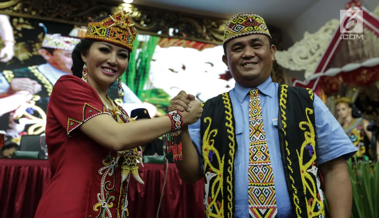 Pasangan calon gubernur Kalimantan Barat Karolin Margret Natasa dan wakilnya Suryadman Gidot tersenyum sambil berjabat tangan saat pengumuman cagub-cawagub PDIP di kantor DPP PDIP Lenteng Agung, Jakarta, Minggu (7/1). (Liputan6.com/Faizal Fanani)