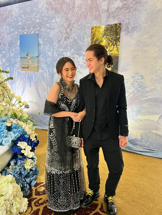 Gemasnya gaya kondangan Dul dan Tissa di sini. Dul tampil rapi mengenakan kemeja yang ditumpuknya dengan setelan jas dan celana panjang yang semuanya serba hitam. Sedangkan Tissa cantik mengenakan dress lace bernuansa hitam tanpa lengan dan selendangnya yang serasi. [Foto: Instagram/tissabiani]