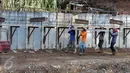 Sejumlah Pekerja  saat mengangkat besi di Pinggiran kali ciliwung, Kalibata, Jakarta, Sabtu (2/4) Pemasangan beton tanggul tersebut untuk meminimalisir banjir kiriman yang sering terjadi di kawasan tersebut. (Liputa6.com/Helmi Afandi)