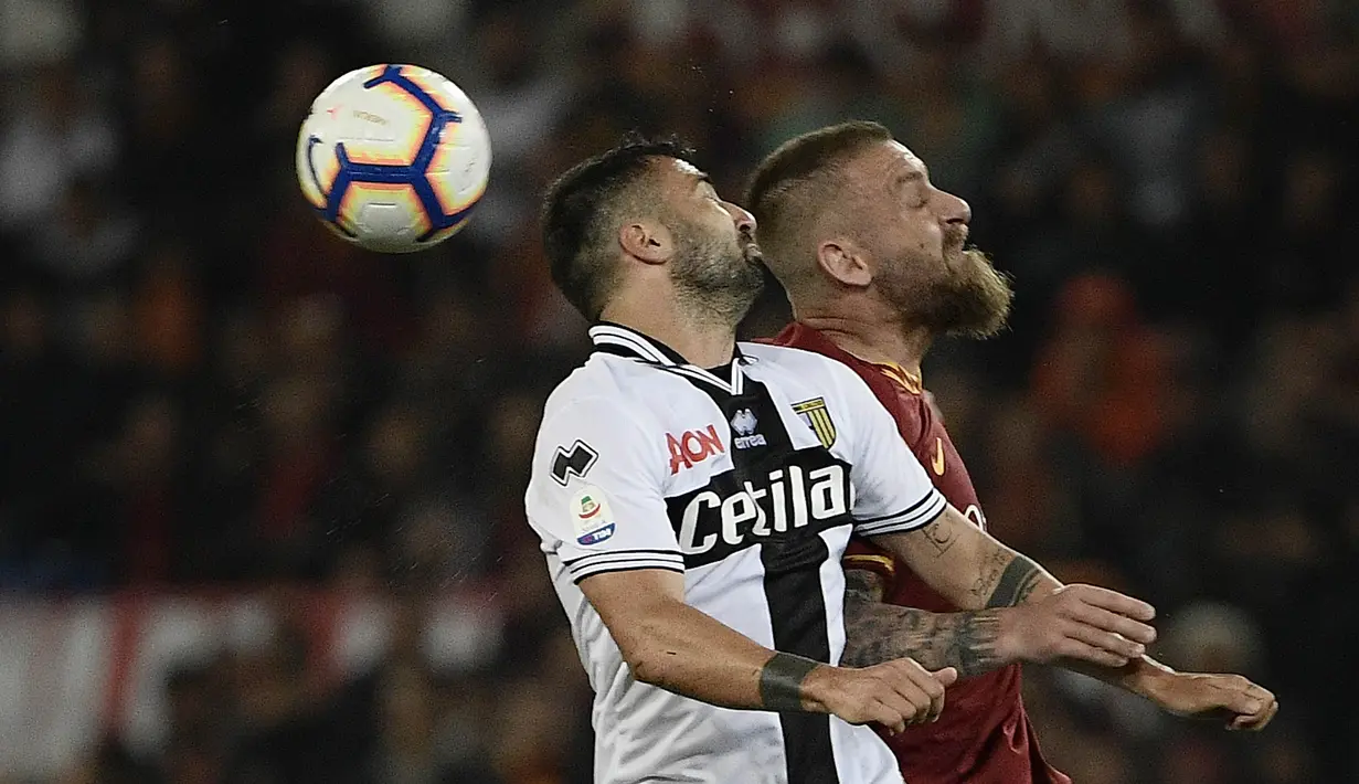 Gelandang AS Roma, Daniele De Rossi, duel udara dengan striker Parma, Fabio Ceravolo, pada laga Serie A di Stadion Olympic, Roma, Minggu (26/5). Laga ini perpisahan bagi De Rossi dan AS Roma setelah 18 tahun. (AFP/Filippo Monteforte)