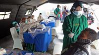 Petugas melakukan swab antigen terhadap pengendara yang melintas di Kedungwaringin, Kabupaten Bekasi, Kamis  (29/4/2021). Satlantas Polres Metro Bekasi melakukan swab antigen dan sosialisasi larangan mudik jelang lebaran di perbatasan Kabupaten Bekasi dan Karawang. (Liputan6.com/Herman Zakharia)