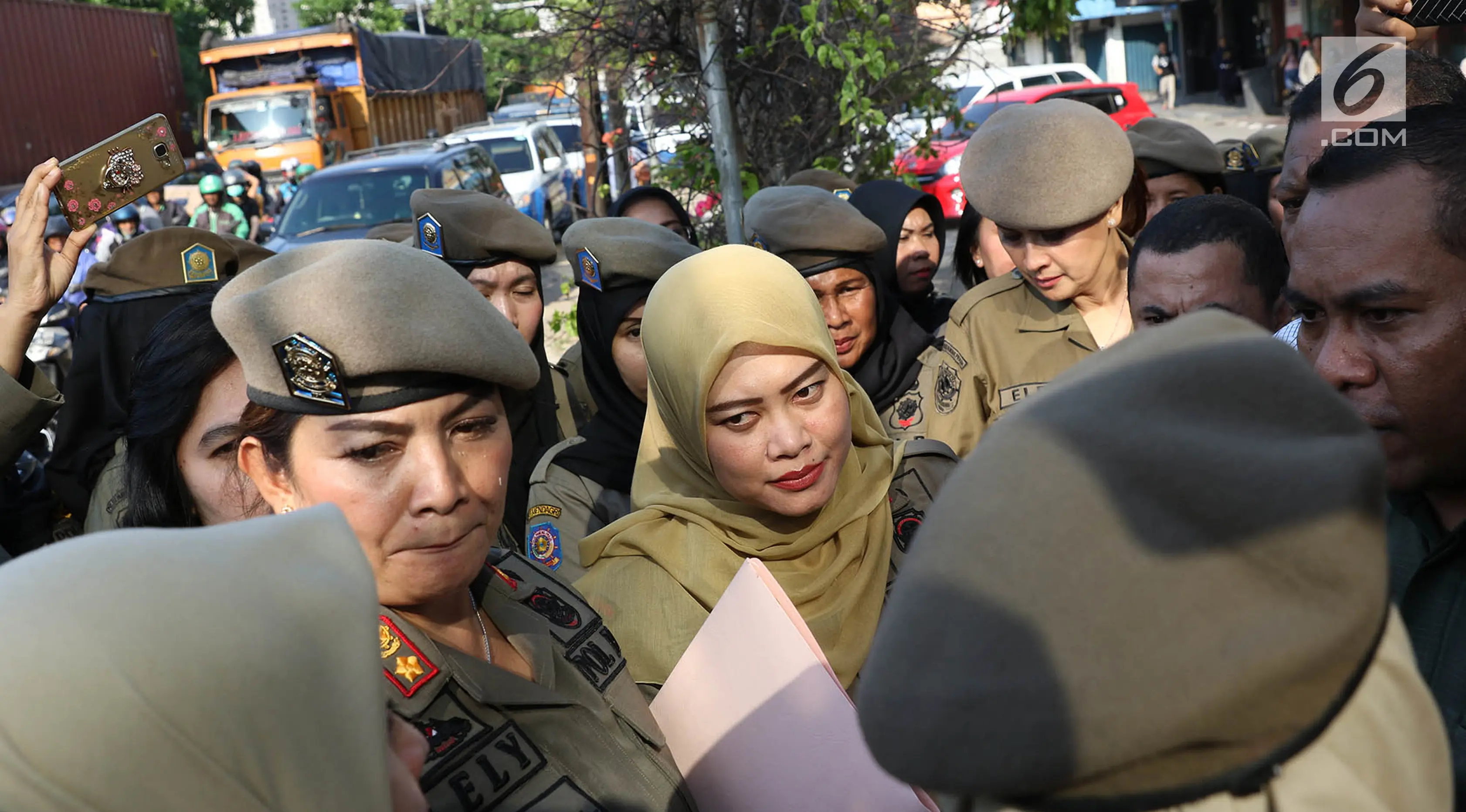 Sejumlah Satpol PP wanita berhadapan dengan petugas keamanan di depan Hotel Alexis, Jakarta, Kamis (29/3). Penutupan Hotel Alexis ditandai dengan pencabutan Tanda Daftar Usaha Pariwisata (TDUP) sejak Kamis, 22 Maret 2018. (Liputan6.com/Immanuel Antonius)