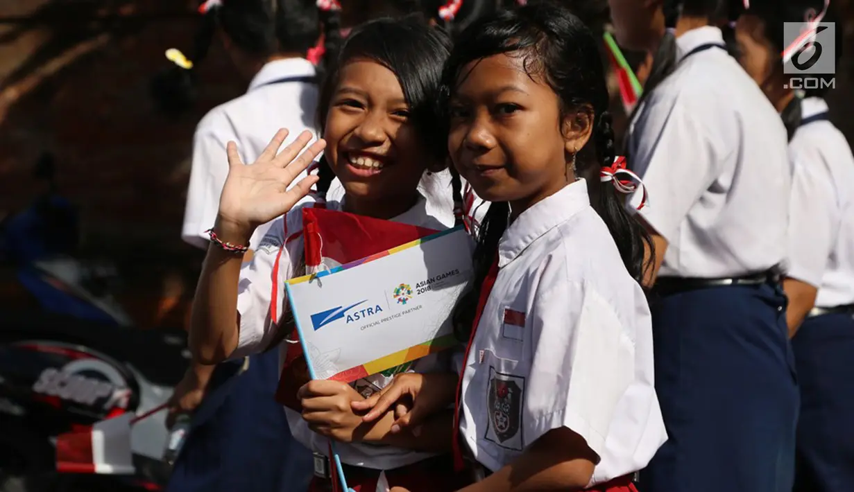 Siswa-siswi sekolah di Denpasar, Bali turut meramaikan pawai obor Asian Games 2018 di Banjar Berseri Astra, Pulugambang, Denpasar, Bali (24/7). (Liputan6.com/Pool/Ilham)