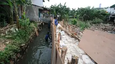 Pekerja Suku Dinas Sumber Daya Air (SDA) memperbaiki tanggul yang kembali jebol di kawasan Jati Padang, Pasar Minggu, Jakarta Selatan, Kamis (18/4). Tanggul jebol akibat derasnya air kali Pulo akibat hujan deras yang melanda kawasan Jakarta pada 16 April 2019 lalu. (Liputan6.com/Herman Zakharia)