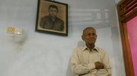 Mantan Anggota Cakrabirawa, Ishak, berfoto dengan latar belakang lukisan saat masih aktif berdinas. Ia masih gagah di usianya yang ke 81 tahun. (Liputan6.com/Muhamad Ridlo)