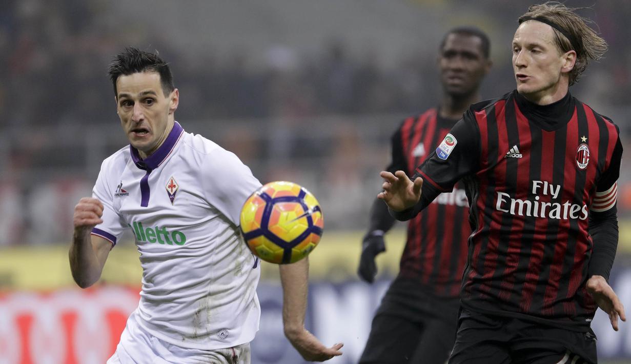 Penyerang Fiorentina, Nikola Kalinic, berebut bola dengan bek AC Milan, Ignazio Abate. Pada laga ini Milan turun menggunakan formasi 4-3-3, sementara Fiorentina memakai skema 3-4-2-1. (AP/Antonio Calanni)