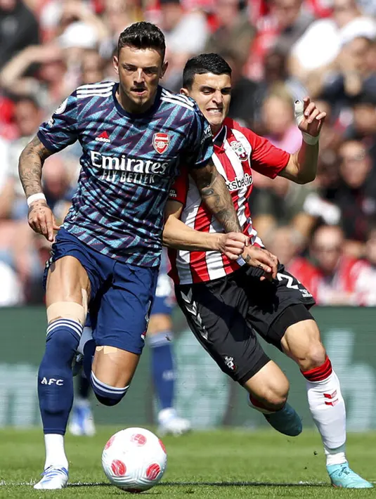 Pemain Arsenal Ben White (kiri) berebut bola dengan pemain Southampton Mohamed Elyounoussi pada pertandingan sepak bola Liga Inggris di St Mary's, Southampton, Inggris, 16 April 2022. Southampton menang 1-0. (Kieran Cleeves/PA via AP)