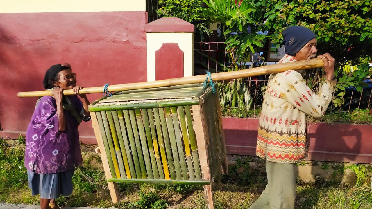 Pasangan tua Katmini dan Harun, warga Kampung Cimaung, Desa Kolot, Kecamatan Cilawu, Garut, Jawa Barat, nampak tengah menggendong kandang ayam untuk diperjualbelikan bagi warga yang membutuhkan.