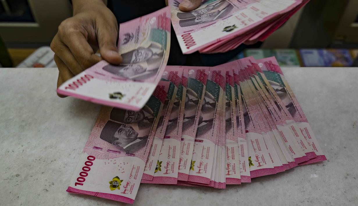 Rupiah ambruk hingga menembus level psikologis di Rp17.500 per dolar AS. Tampak dalam foto, seorang menghitung uang kertas Rupiah di salah satu kantor penukaran uang, Jakarta, Selasa 12 Mei 2026, di tengah depresiasi Rupiah terhadap Dolar Amerika Serikat. (BAY ISMOYO/AFP)