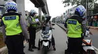 Anggota Satlantas Jakarta Timur merazia sepeda motor yang masuk jalur Transjakarta di kawasan Jatinegara, Jakarta, Kamis (7/2). Pelanggaran ini sering terjadi pada pagi hari. (Merdeka.com/Imam Buhori)