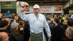 Penjual melelang potongan daging selama lelang tahunan di Smithfield Market, kota London, 24 Desember 2018. Dalam tradisi Natal sejak zaman Victoria ini calon pembeli mendapatkan diskon besar-besaran berbagai daging sapi dan domba. (NIKLAS HALLE'N/AFP)