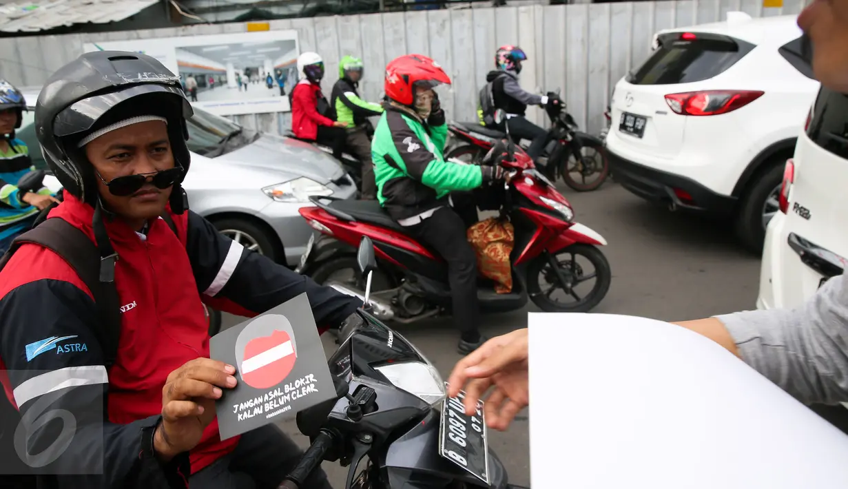 Aktivis HAM memberi brosur kepada para pengendara di Bundaran HI, Jakarta, Kamis (10/12/2015). Aksi untuk memperingati Hari HAM Internasional yang jatuh setiap tanggal 10 Desember. (Liputan6.com/Faizal Fanani)