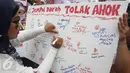 Massa dari Indonesia Bergerak menggelar aksi menolak Gubernur DKI, Basuki Tjahaja Purnama (Ahok) di Patung Arjuna Wiwaha, Jakarta, Kamis (22/9). Mereka membubuhkan cap jempol menggunakan darah sebagai simbol penolakannya. (Liputan6.com/Immanuel Antonius)