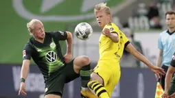 Pemain Borussia Dortmund, Erling Haaland, berebut bola dengan pemain Wolfsburg, Xaver Schlager, pada laga Bundesliga, Minggu (24/5/2020). Borussia Dortmund menang 2-0 atas Wolfsburg. (AP/Michael Sohn)