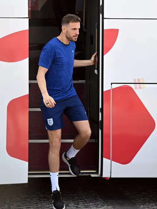 Gelandang Inggris, Jordan Henderson turun dari busa di Doha (11/12/2022). Bus yang membawa Timnas Inggris meninggalkan hotel menuju bandara untuk membawa mereka kembali ke kampung halaman. (AFP/Paul Ellis)