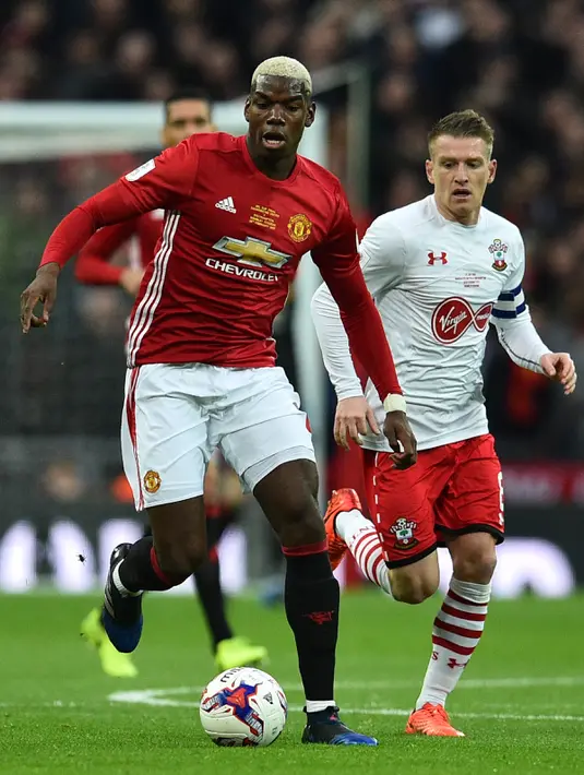 Gelandang Manchester United, Paul Pogba berusaha menggiring bola dari kejaran gelandang Steven Davis pada final Piala Liga Inggris di Stadion Wembley, London, (27/2). MU menang atas Southampton dengan skor 3-2. (AFP Photo / Glyn Kirk)