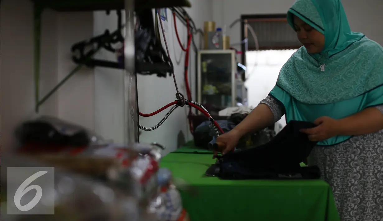 Pekerja menyetrika pakaian konsumen yang menggunakan jasa pencucian pakaian (laundry) di Jakarta, Selasa (12/7). Usaha pencucian pakaian mengalami peningkatan omset hingga 20% dibanding hari biasa setelah libur lebaran. (Liputan6.com/Faizal Fanani)