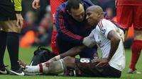 Gelandang Manchester United, Ashley Young, saat mendapat perawatan dari tim medis ketika menghadapi Liverpool, di ajang Premier League, Minggu (17/1/2016). (AFP/Paul Ellis)