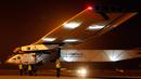 Salah satu teknisi  memegang pipa pelindung angin dari pesawat Solar Impulse 2 di bandara Ahmedabad, India, Rabu (11/3/2015). Pesawat buatan Swiss tersebut mendarat setelah menempuh perjalanan selama 15 jam.  (Reuters/Amit Dave)