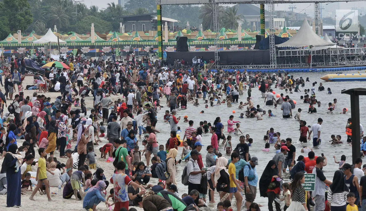 Warga memanfaatkan libur nasional Pilkada Serentak 2018 dengan memadati kawasan Pantai Ancol, Jakarta, Rabu (27/6). Pada program gratis masuk Ancol dalam rangka HUT Jakarta ini, antusias pengunjung mencapai 19.000 jiwa. (Merdeka.com/Iqbal S. Nugroho)