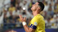 Gestur kecewa pemain Al-Nassr, Cristiano Ronaldo pada laga lanjutan Liga Arab Saudi melawan Abha yang berlangsung di King Saud University Stadium, Riyadh, Arab Saudi, Jumat (06/10/2023) malam WIB. Al-Nassr yang awalnya berhasil unggul 2-0 malah kebobolan dua gol dan membuat kedudukan akhir menjadi 2-2. (AFP/Fayez Nureldine)