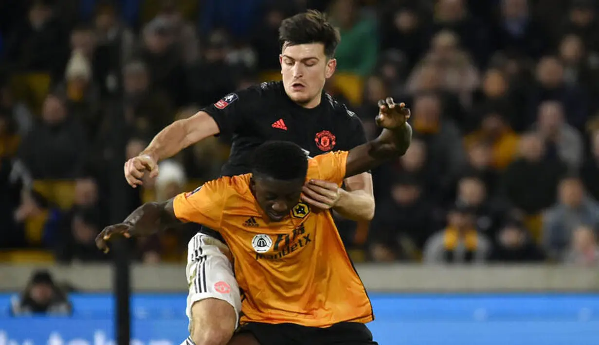 Bek Manchester United, Harry Maguire, mengawal pemain Wolverhampton Wanderers, Benny Ashley-Seal, pada laga Piala FA di Stadion Molineux, Sabtu (4/1/2020). Kedua tim bermain imbang 0-0. (AP/Rui Vieira)