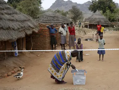 Warga suku Karamojong memasukkan kertas suara kedalam kotak di TPS desa dekat kota Kaabong, Uganda, (18/2). Uganda memiliki berbagai macam suku yang warganya masih tertinggal dengan kota - kota besar. (REUTERS / Goran Tomasevic)