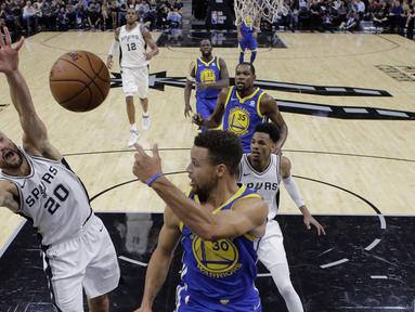 Aksi pemain Warriors, Stephen Curry (30) melakukan umpan melewati adangan pemain Spurs, Manu Ginobili (20) pada laga NBA basketball game di AT&T Center, San Antonio, (2/11/2017) waktu setempat. Warriors menang 112-92. (AP/Eric Gay)