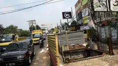 Sejumlah pengendara melintas di depan proyek galian sedalam 12 meter di Jalan Alternatif Cibubur, Jakarta, Senin (10/11/2014). (Liputan6.com/Faizal Fanani) 