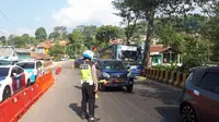 Petugas kepolisian sedang mengurai kendaraan yang melalui jalur Nagreg, Kabupaten Bandung. (Huyogo Simbolon)
