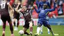 Pemain Leicester City, Luke Thomas, berebut bola dengan pemain Chelsea, N'Golo Kante, pada laga final Piala FA di Stadion Wembley, Sabtu (15/5/2021). The Foxes menang dengan skor 1-0. (Nick Potts/Pool via AP)