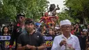 Acara ini berlangsung meriah melibatkan arak-arakan patung raksasa sebagai simbol pembersihan unsur negatif, serta menampilkan perpaduan budaya Bali dan ikon khas Surabaya. Tampak dalam foto, seorang penganut Hindu membawa Ogoh-ogoh, patung yang melambangkan roh jahat, selama pawai menjelang Nyepi di Surabaya pada Rabu 18 Maret 2026. (JUNI KRISWANTO/AFP)