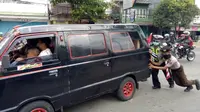 Relawan dan polisi mendorong mobil pemudik yang mogok di Gombong, Kebumen pada arus mudik lebaran 2018, Selasa, 12 Juni 2018. (Liputan6.com/Polres Kebumen/Muhamad Ridlo)