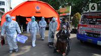 Petugas mengevakuasi pasien COVID-19 untuk menjalani perawatan di dalam tenda darurat di RSUD Kota Bekasi, Jumat (25/06/2021). Puluhan pasien covid-19 saat ini dirawat dalam tenda darurat karena keterisian tempat tidur yang penuh akibat lonjakan kasus. (merdeka.com/Arie Basuki)