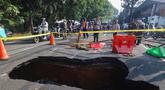 Pengendara melintas di sisi ruas jalan yang ditutup sebagian akibat amblas di Jalan Raya Lenteng Agung, Jakarta Selatan, Jumat (29/5/2026). (merdeka.com/Arie Basuki)