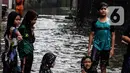 Anak-anak bermain air saat banjir merendam lingkungan rumah tempat tinggal mereka di kawasan kecamatan Kebayoran Baru, Jakarta, Senin (25/01/2021). Hujan deras yang mengguyur Jakarta hari ini, Senin (25/1) menyebabkan terjadinya banjir di kawasan permukiman tersebut. (Liputan6.com/Johan Tallo)