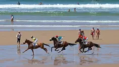 Para joki beraksi dalam kejuaraan tahunan pacuan kuda pantai di Loredo, Santander, Spanyol, (24/7/2016). (AFP/Cesar Manso)
