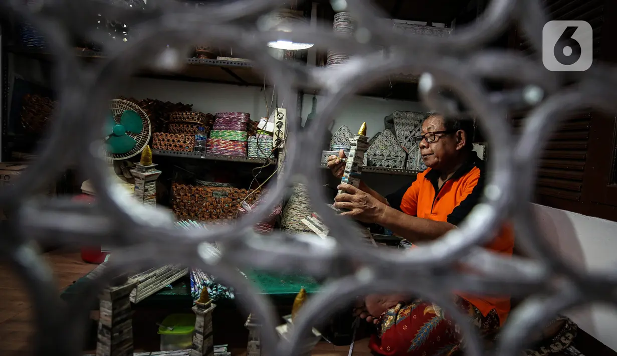 Sugito (68) menyelesaikan pembuatan miniatur Monas dari kertas koran bekas di Bank Sampah Tri Alam Lestari, Pesanggrahan, Jakarta Selatan, Rabu (9/6/2021). Kemampuan untuk membuat kerajinan itu ia dapat secara otodidak. (Liputan6.com/Johan Tallo)