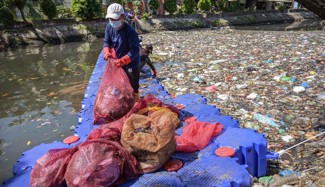Mereka menemukan plastik sekali pakai, styrofoam, kemasan makanan, hingga limbah rumah tangga dari kawasan permukiman padat. Tampak dalam foto, aktivis dari Ecoton (Ecological Observation and Wetlands Conservation) bersama pekerja dari Dinas Lingkungan Hidup Pemerintah Kota Surabaya, Jawa Timur, membersihkan sampah dari Sungai Kali Tebu, pada Senin 11 Mei 2026. (JUNI KRISWANTO/AFP)