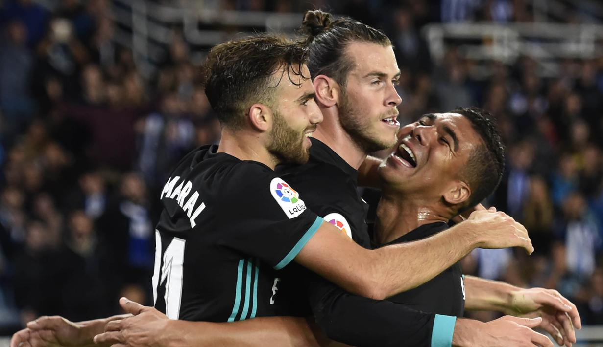 Para pemain Real Madrid merayakan gol yang dicetak oleh Gareth Bale ke gawang Real Sociedad pada laga La Liga di Stadion Anoeta, Minggu (17/9/2017). Real Madrid menang 3-1 atas Real Sociedad. (AFP/Ander Gillenea)