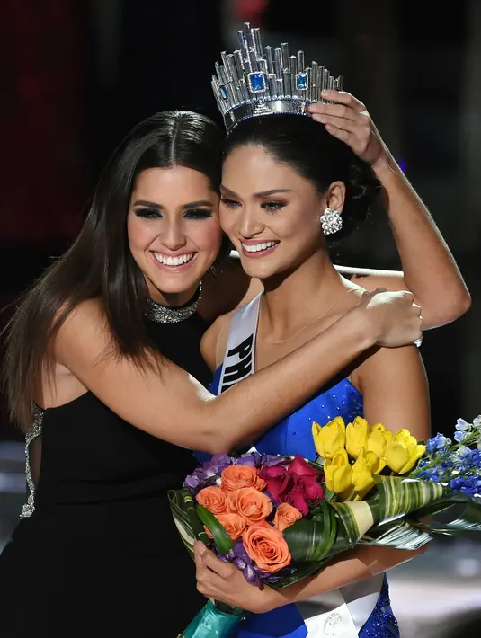 Miss Universe 2014, Paulina Vega memeluk Miss Universe 2015, Pia Alonzo Wurtzbach setelah mahkota dipasang. Senyum manis menghiasi kedua wajah wanita cantik ini. (AFP/Bintang.com)