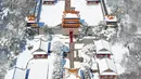 Pemandangan Taman Beiling saat diselimuti salju di Shenyang di provinsi Liaoning, China (15/3). Salju tebal tersebut membuat pemandangan di taman itu indah, karena perpaduan atap yang berwarna emas dengan putih salju. (AFP)