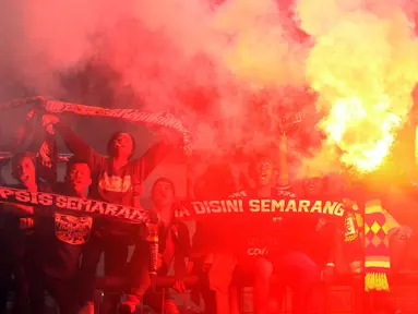 Suporter PSIS menyalakan suar saat merayakan kemenangan timnya melawan Martapura FC di Final tempat ketiga Liga 2 Indonesia di Stadion GBLA, Bandung, Selasa (28/11). PSIS unggul 6-4 dan lolos ke Liga 1 Indonesia. (Liputan6.com/Helmi Fithriansyah)