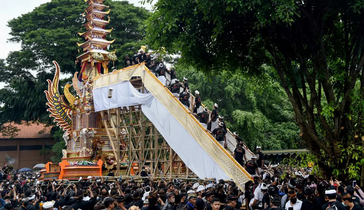 Orang-orang membawa jenazah mendiang Raja Ida Cokorda Pemecutan XI atau Anak Agung Ngurah Manik Parasara saat upacara ngaben di Denpasar, Bali, 21 Januari 2022. Anak Agung Ngurah Manik Parasara meninggal pada Desember lalu di usia 76 tahun. (SONY TUMBELAKA/AFP)
