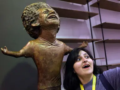 Seorang peserta World Youth Forum berswafoto dengan patung bintang Liverpool, Mohamed Salah yang mulai dipamerkan di Sharm al-Sheikh, Mesir, Senin (5/11). Namun, bukannya menarik pujian, patung Mo Salah tersebut malah mendapat ejekan. (AP/Ayman Aref)