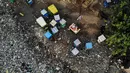 Pandangan udara menunjukkan seorang pria berjalan di samping becak yang diparkir di dekat saluran pembuangan air limbah yang dipenuhi sampah di lingkungan berpenghasilan rendah di New Delhi, India (4/10/2019). (AFP Photo/Noemi Cassanelli)
