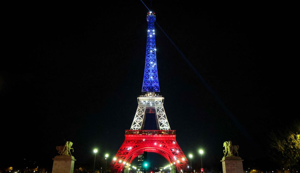 Menara Eiffel diterangi dengan warna bendera Prancis (biru, putih, dan merah) pada tanggal 12 dan 13 November 2025 sebagai penghormatan kepada para korban. Tampak sebuah foto memperlihatkan Menara Eiffel yang diterangi dengan warna bendera nasional Prancis saat peringatan ke-10 serangan teroris Paris yang terjadi pada 2015, di Paris, pada 12 November 2025. (Ludovic MARIN/AFP)