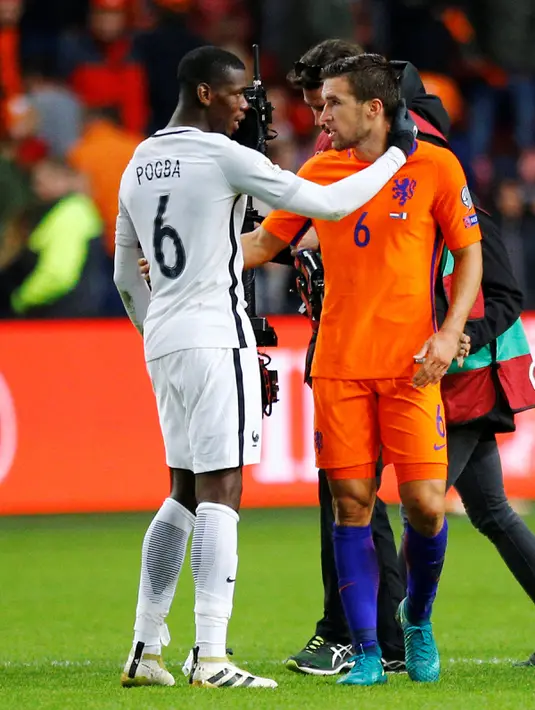 Pemain Prancis Paul Pogba dan pemain Belanda Kevin Strootman seusai pertandingan kualifikasi Piala Dunia 2018 di stadion Arena di Amsterdam, Belanda, Senin (10/10). Kedua pemain itu terkena kartu kuning akibat beradu mulut. (REUTERS/Michael Kooren)